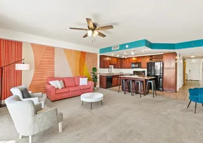 a living room with a red couch and a kitchen at BeachFrnt 2 Hottub 5 Pools Jet Ski in Panama City Beach