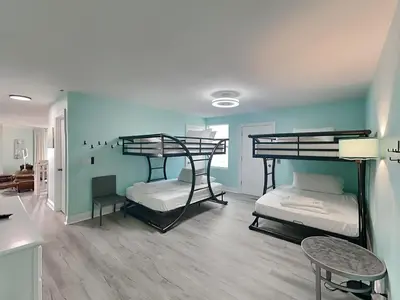 a room with two bunk beds and a table at Lion On The Beach in Panama City Beach
