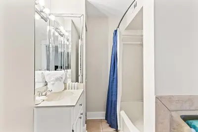 a white bathroom with a sink and a mirror at The Summit 301 in Panama City Beach