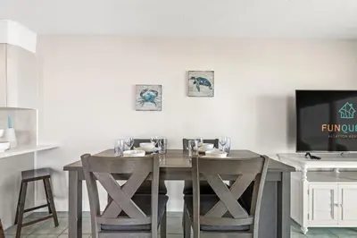 a dining room table with two chairs and a television at The Summit 301 in Panama City Beach