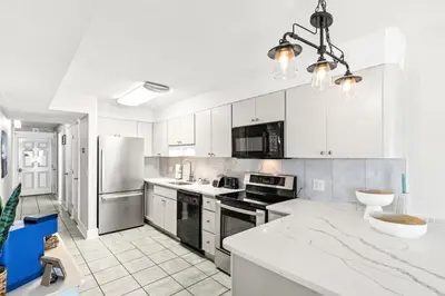 a large kitchen with white cabinets and appliances at The Summit 301 in Panama City Beach