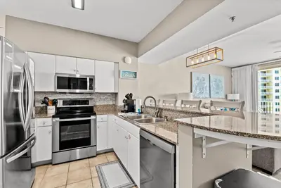 a kitchen with white cabinets and stainless steel appliances at Spacious 2-Bedroom Condo Beachfront Resort! By Dolce Vita Getaways PCB! in Panama City Beach