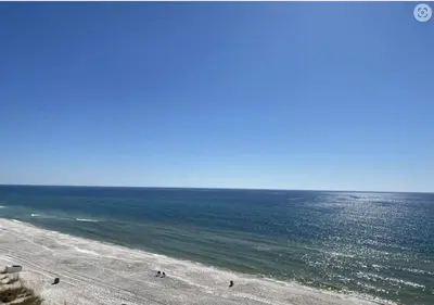 a beach with people standing on the sand and the ocean at Pinnacle Port B3-706 in Panama City Beach