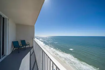 two chairs on a balcony looking out at the ocean at Stunning Beach front condo in Panama City Beach