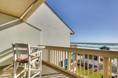 a white chair sitting on a balcony overlooking the beach at Steps to Sand PCB Condo with Gulf-View Balconies! in Panama City Beach