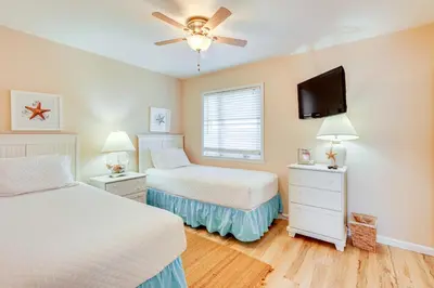 a bedroom with two beds and a flat screen tv at Steps to Sand PCB Condo with Gulf-View Balconies! in Panama City Beach