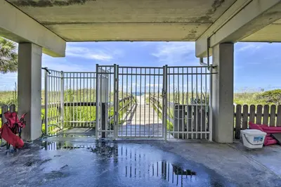 an open gate with a puddle of water on a patio at Steps to Sand PCB Condo with Gulf-View Balconies! in Panama City Beach