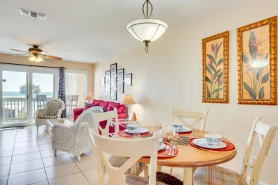 a dining room and living room with a table and chairs at Steps to Sand PCB Condo with Gulf-View Balconies! in Panama City Beach