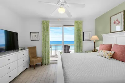 a bedroom with a bed and a window with the ocean at Calypso Resort By Sand Seeker Vacations in Panama City Beach