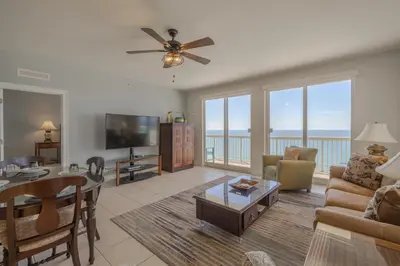 a living room with a couch and a table and a tv at Calypso Resort By Sand Seeker Vacations in Panama City Beach