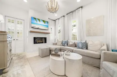 a living room with a couch and a fireplace at Hazel's Cottage and Carriage House in Rosemary Beach