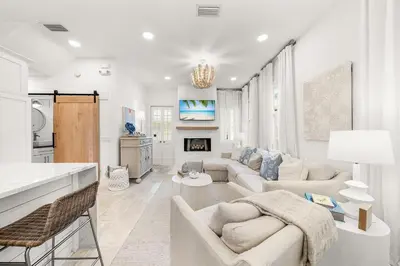 a living room with a couch and a fireplace at Hazel's Cottage and Carriage House in Rosemary Beach