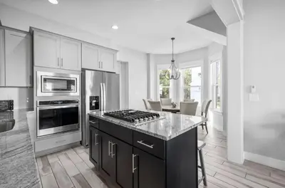 a kitchen with white cabinets and a stove top oven at Available for Spring Break! Seas The Day at Inlet Beach in Inlet Beach