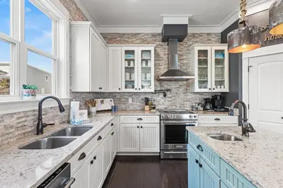 a kitchen with white cabinets and blue appliances at Blue Sky Bungalow in Inlet Beach