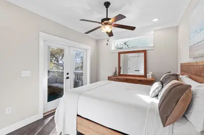 a bedroom with a bed and a ceiling fan at Blue Sky Bungalow in Inlet Beach