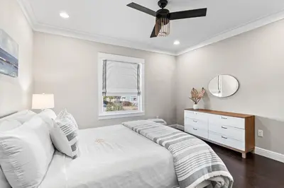 a white bedroom with a bed and a ceiling fan at Blue Sky Bungalow in Inlet Beach