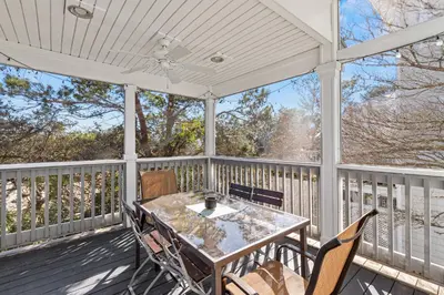 a patio with a table and chairs on a deck at Blue Sky Bungalow in Inlet Beach