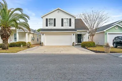 a white house with a palm tree and a driveway at Beach House - Paradise Palace by Panhandle Getaways in Panama City Beach