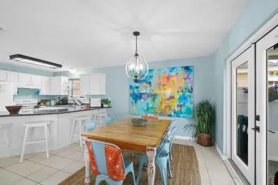 a kitchen and dining room with a wooden table and chairs at Beach House - Paradise Palace by Panhandle Getaways in Panama City Beach