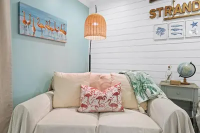 a couch with a pillow on it in a room at Pet-friendly condo, less than 5 min walk to beach, beach chairs, wagon, umbrella etc. included! in Panama City Beach