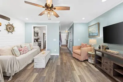 a living room with a couch and a flat screen tv at Pet-friendly condo, less than 5 min walk to beach, beach chairs, wagon, umbrella etc. included! in Panama City Beach