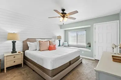 a bedroom with a bed and a ceiling fan at Pet-friendly condo, less than 5 min walk to beach, beach chairs, wagon, umbrella etc. included! in Panama City Beach