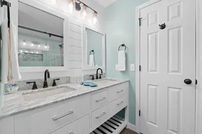 a white bathroom with a sink and a mirror at Pet-friendly condo, less than 5 min walk to beach, beach chairs, wagon, umbrella etc. included! in Panama City Beach