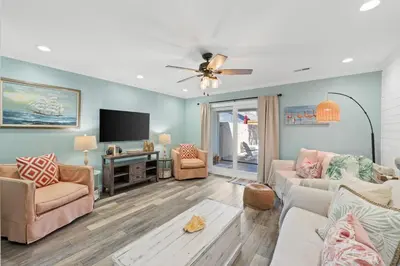 a living room with a couch and a tv at Pet-friendly condo, less than 5 min walk to beach, beach chairs, wagon, umbrella etc. included! in Panama City Beach