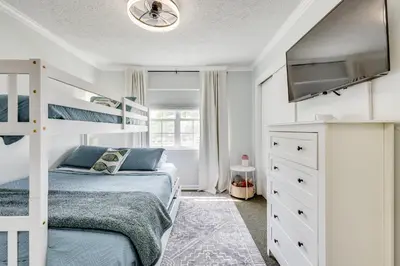 a bedroom with a bunk bed and a flat screen tv at Boat Dock and Game Room Waterfront Panama City Gem in Lynn Haven