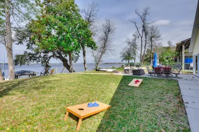 a picnic table in the grass next to a house at Boat Dock and Game Room Waterfront Panama City Gem in Lynn Haven