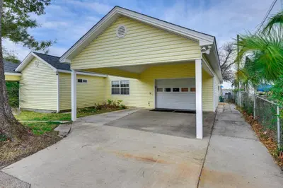 a yellow house with a garage at Boat Dock and Game Room Waterfront Panama City Gem in Lynn Haven
