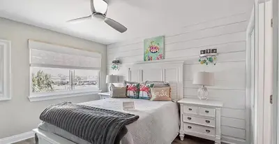 a white bedroom with a bed and a window at Ocean Bliss by Emerald Coast Retreats in Panama City Beach