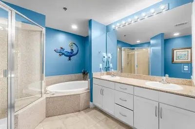 a blue bathroom with two sinks and a shower at Laketown Wharf #0722 in Panama City Beach