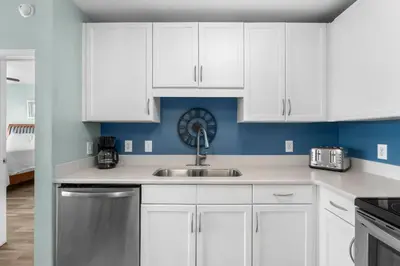 a kitchen with white cabinets and a sink at Laketown Wharf #0722 in Panama City Beach