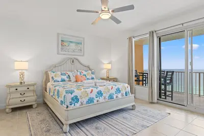 a bedroom with a bed and a ceiling fan at Treasure Shores–3BR Beachfront Corner Unit sleeps 8 with Stunning Gulf Views! in Panama City Beach