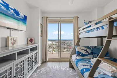 a bedroom with bunk beds and a balcony at Treasure Tides–3BR Beachfront Corner Unit sleeps 8 with Stunning Gulf Views! in Panama City Beach