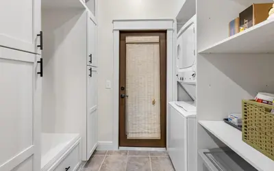 a hallway with a door in a kitchen with white cabinets at Sea Stars by Oversee 30A in Seacrest