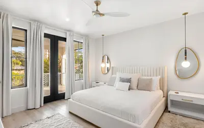 a white bedroom with a bed and a balcony at Sapphire Bay by Oversee 30A in Santa Rosa Beach