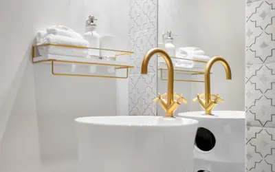 two sinks in a white bathroom with gold faucets at Sapphire Bay by Oversee 30A in Santa Rosa Beach