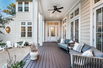 a porch with a blue couch and a ceiling fan at Our Tree House by Oversee 30A in Inlet Beach