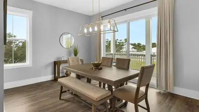 a dining room with a wooden table and chairs at Queen Palm in Inlet Beach