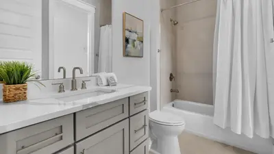 a bathroom with a sink and a toilet and a tub at Queen Palm in Inlet Beach