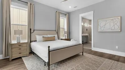 a bedroom with a bed and a dresser and windows at Queen Palm in Inlet Beach