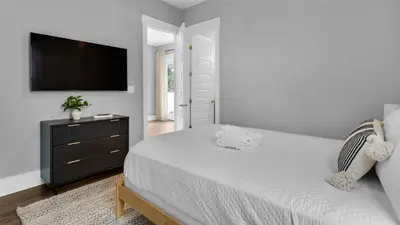 a bedroom with a bed and a flat screen tv at Queen Palm in Inlet Beach
