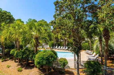 a swimming pool with palm trees and a resort at 30A - Cassine Station by Panhandle Getaways in Santa Rosa Beach