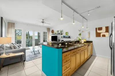 a kitchen with a blue island in the middle at 30A - Cassine Station by Panhandle Getaways in Santa Rosa Beach