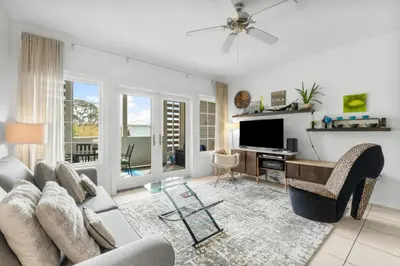 a living room with a couch and a desk and a television at 30A - Cassine Station by Panhandle Getaways in Santa Rosa Beach