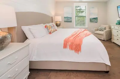a bedroom with a large white bed and a chair at Chic Seagrove Retreat- Modern 30A Coastal Living in Santa Rosa Beach