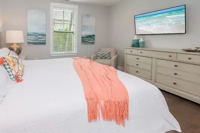 a bedroom with a white bed and a tv on the wall at Chic Seagrove Retreat- Modern 30A Coastal Living in Santa Rosa Beach