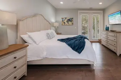 a bedroom with a large white bed with a wooden headboard at Chic Seagrove Retreat- Modern 30A Coastal Living in Santa Rosa Beach